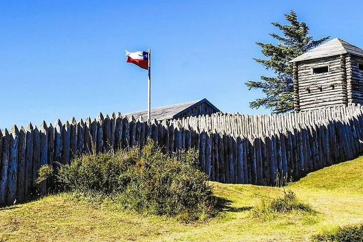 Hölzerne Palisade, Wachturm und chilenische Flagge in Fuerte Bulnes